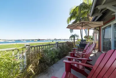 a row of chairs on a porch with the beach at Bayfront Paradise- Bay Views & Boardwalk Patio in San Diego