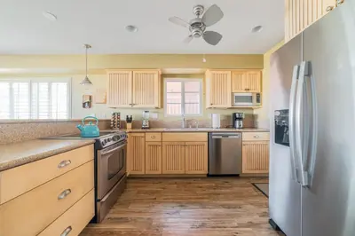 a kitchen with wooden cabinets and stainless steel appliances at Bayfront Paradise- Bay Views & Boardwalk Patio in San Diego