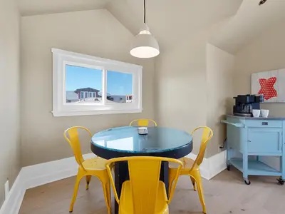 a dining room with a blue table and yellow chairs at Kennebeck Views - Ocean View, Roof Patio, Steps to Beach & Boardwalk in San Diego
