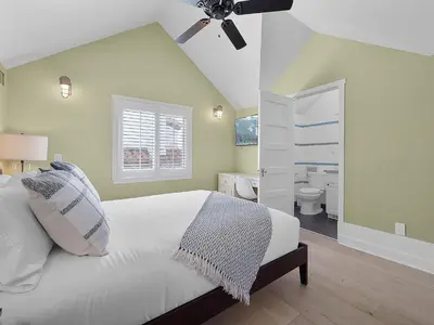 a bedroom with a white bed and a bathroom at Kennebeck Views - Ocean View, Roof Patio, Steps to Beach & Boardwalk in San Diego