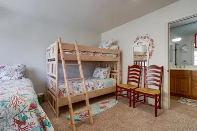 a bedroom with bunk beds and a bed and a mirror at Bayfront Dream - Bay Views, Rooftop Patio, & Garage! in San Diego