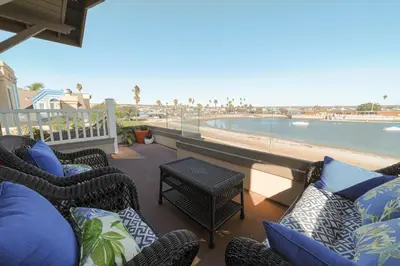 a balcony with chairs and a view of the beach at Bayfront Dream - Bay Views, Rooftop Patio, & Garage! in San Diego