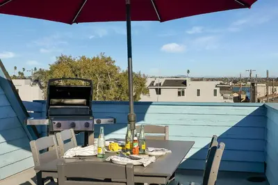 a table with an umbrella on top of a roof at Ormond Retreat w Ocean View, Steps2beach & Garage in San Diego