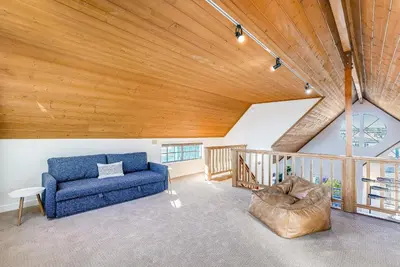 a living room with a blue couch and a wooden ceiling at Ormond Retreat w Ocean View, Steps2beach & Garage in San Diego