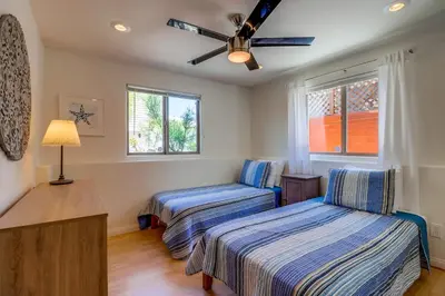 a bedroom with two beds and a ceiling fan at Beach Oasis - Rooftop, Steps2Sand and Water Views in San Diego