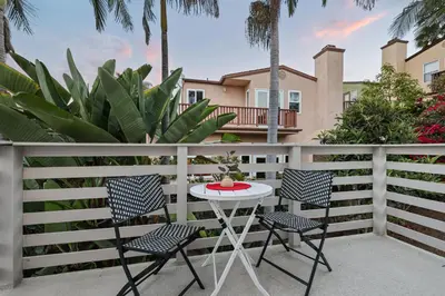 a patio with two chairs and a table on a fence at Modern Dream Home - Fire Pit, Grill, Large Yard & AC in Encinitas