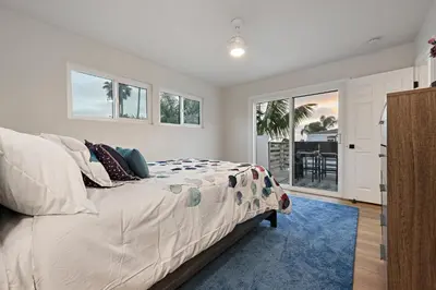 a bedroom with a large bed with a blue rug at Modern Dream Home - Fire Pit, Grill, Large Yard & AC in Encinitas