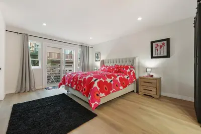 a bedroom with a bed with red comforter and a window at Modern Dream Home - Fire Pit, Grill, Large Yard & AC in Encinitas