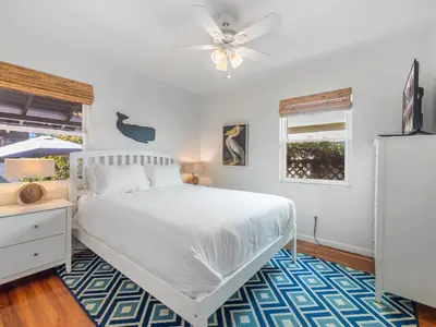 a bedroom with a white bed and a ceiling fan at La Jolla Ocean Dream - Walk 2 Beach - Dog Friendly in San Diego