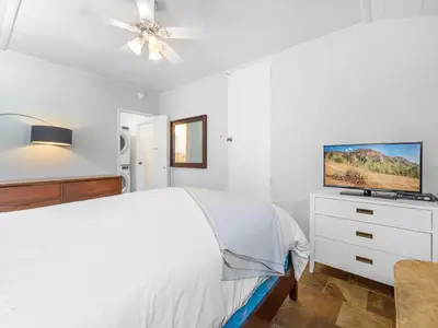 a white bedroom with a bed and a flat screen tv at La Jolla Ocean Dream - Walk 2 Beach - Dog Friendly in San Diego