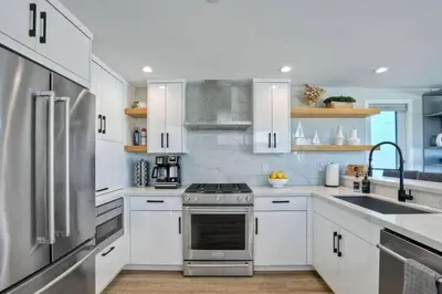 a kitchen with white cabinets and a stainless steel refrigerator at NEW Luxury Beach Home I 3BR I Balcony I Firepit in San Diego