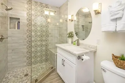 a white bathroom with a shower and a sink at Oceanfront Home with Stunning View in Oceanside
