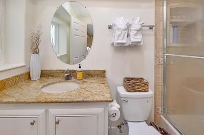 a bathroom with a sink and a mirror and a toilet at Oceanfront Home with Stunning View in Oceanside