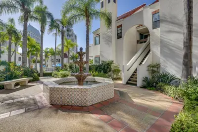 a fountain in the courtyard of a building with palm trees at Downtown San Diego Condo 1 Mi to Gaslamp Quarter in San Diego