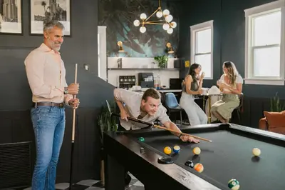a man and a woman playing pool in a room at Hotel Zindel in San Diego