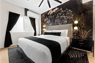 a bedroom with a large bed with a black and white blanket at Hotel Zindel in San Diego