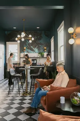 a man sitting on a couch in a living room at Hotel Zindel in San Diego
