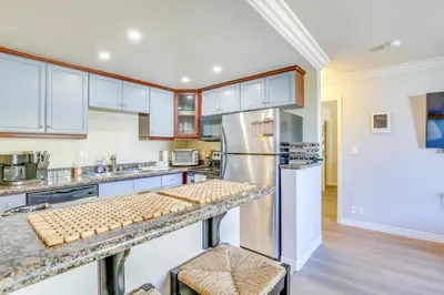 a kitchen with white cabinets and a stainless steel refrigerator at Sunny Imperial Beach Condo - Walk to Ocean! in Imperial Beach
