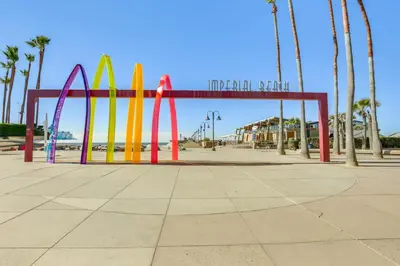a colorful arch in a park with palm trees at Sunny Imperial Beach Condo - Walk to Ocean! in Imperial Beach