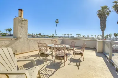 a patio with a table and chairs and palm trees at Sunny Imperial Beach Condo - Walk to Ocean! in Imperial Beach
