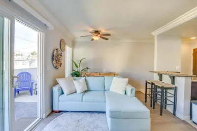 a living room with a blue couch and a table at Sunny Imperial Beach Condo - Walk to Ocean! in Imperial Beach