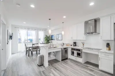 a kitchen with white cabinets and a table and chairs at Park Blvd 301 - Modern - Urban Oasis - SPA in San Diego