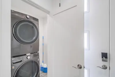 a washing machine in a bathroom next to a door at Park Blvd 302 - Newly Built - Spa - Central in San Diego