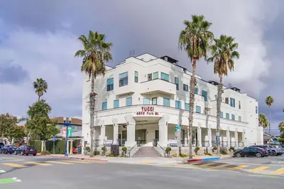 a white building with palm trees in front of it at Park Blvd Paradise 304 New construction, king bed! in San Diego