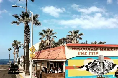 a restaurant on a street with palm trees and the ocean at Mile to Beach! Tiki Master Suite in Oceanside