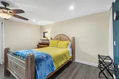 a bedroom with a bed and a ceiling fan at Mile to Beach! Tiki Master Suite in Oceanside