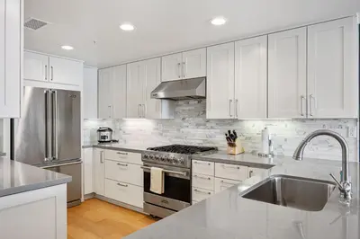 a kitchen with white cabinets and a stove top oven at Escape to Neptune in San Diego