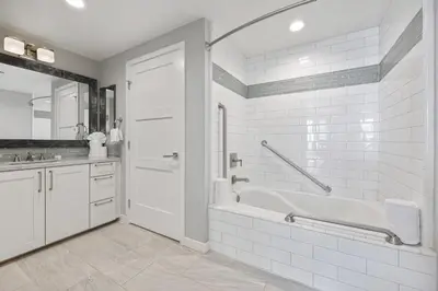 a white bathroom with a tub and a sink at Escape to Neptune in San Diego