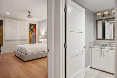 a bedroom with a bed and a bathroom with a sink at Escape to Neptune in San Diego