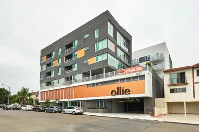 a large apartment building with cars parked in a parking lot at Luxury 2BD 2BA, BRAND NEW/PETS/CLOSE TO EVERYTHING/BOHO+COZY VIBES in San Diego