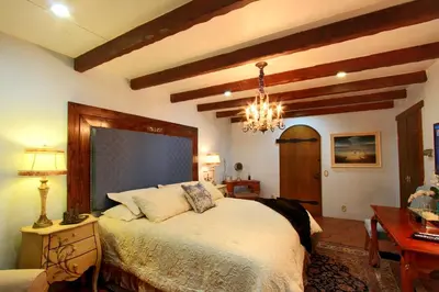 a bedroom with a bed and a table and a chandelier at Vineyard Hacienda in El Cajon