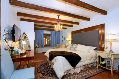 a bedroom with a large bed and a chandelier at Vineyard Hacienda in El Cajon