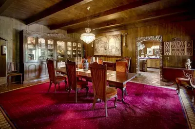 a dining room with a table and chairs on a red rug at Vineyard Hacienda in El Cajon