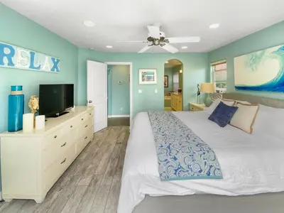 a bedroom with a white bed and a flat screen tv at Massive Mission Beach Home - Fire Pit & Deck in San Diego