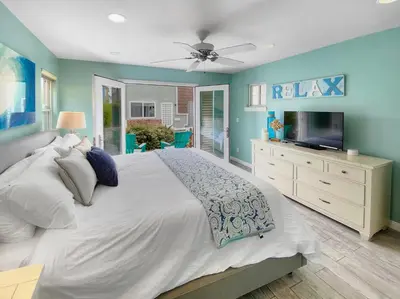 a bedroom with a large bed and a television at Massive Mission Beach Home - Fire Pit & Deck in San Diego