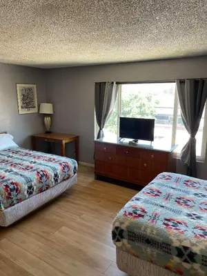 a bedroom with two beds and a tv and a window at Valley Motel El Cajon San Diego in El Cajon