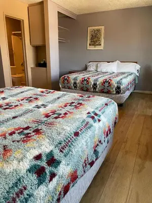 two beds in a hotel room with a colorful blanket at Valley Motel El Cajon San Diego in El Cajon