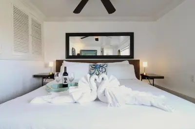 a bedroom with a white bed with towels on it at Ocean Bluff Hideaway Unit B in San Clemente