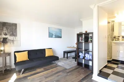 a living room with a black couch and a table at Ocean Bluff Hideaway Unit B in San Clemente