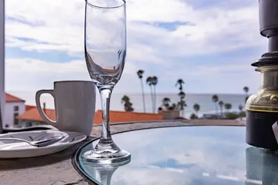 a wine glass sitting on a table next to a cup at Ocean Bluff Hideaway Unit B in San Clemente