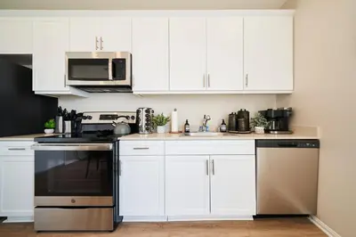 a kitchen with white cabinets and a stove top oven at NEW Organic Modern Luxury 1BD/1BA- close to everything! in San Diego