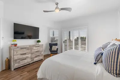 a white bedroom with a bed and a ceiling fan at CBS-2369 - Cardiff Panoramic Paradise in Cardiff-by-the-Sea