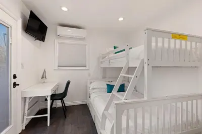 a white bedroom with a bunk bed and a desk at CB-3900A - Coastal Carlsbad Surfer's Dream in Carlsbad