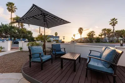 a deck with chairs and a table and an umbrella at CB-3900A - Coastal Carlsbad Surfer's Dream in Carlsbad