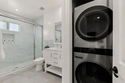 a bathroom with a washer and dryer next to a toilet at CB-3900A - Coastal Carlsbad Surfer's Dream in Carlsbad