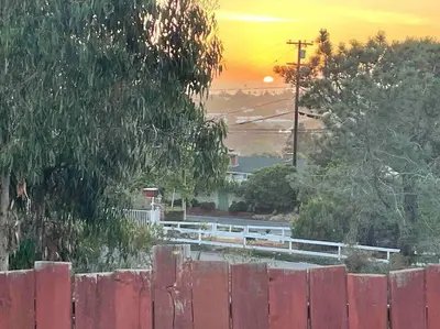 a sunset behind a red fence with a fence at Private Hacienda with Heated Pool and Spa with Amazing Views in Del Mar